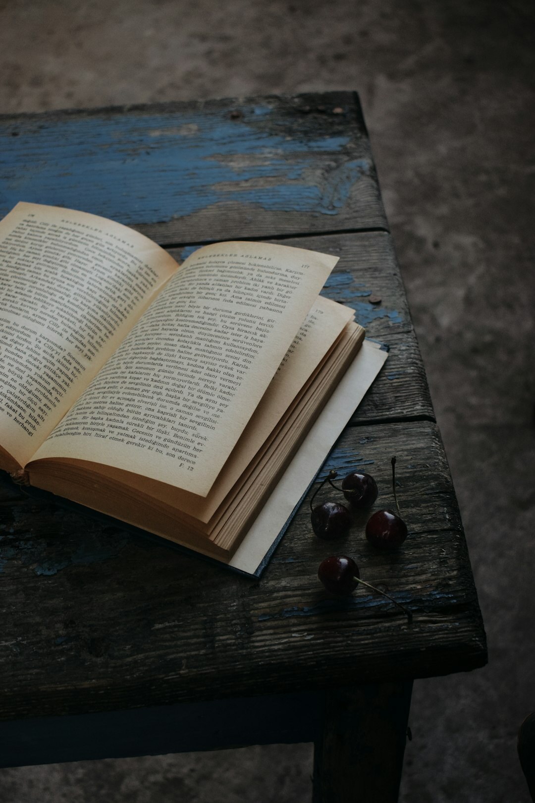 Open vintage book with worn pages on a dark table