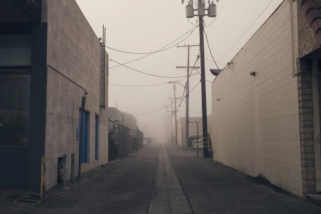 Foggy narrow alley between old stone buildings