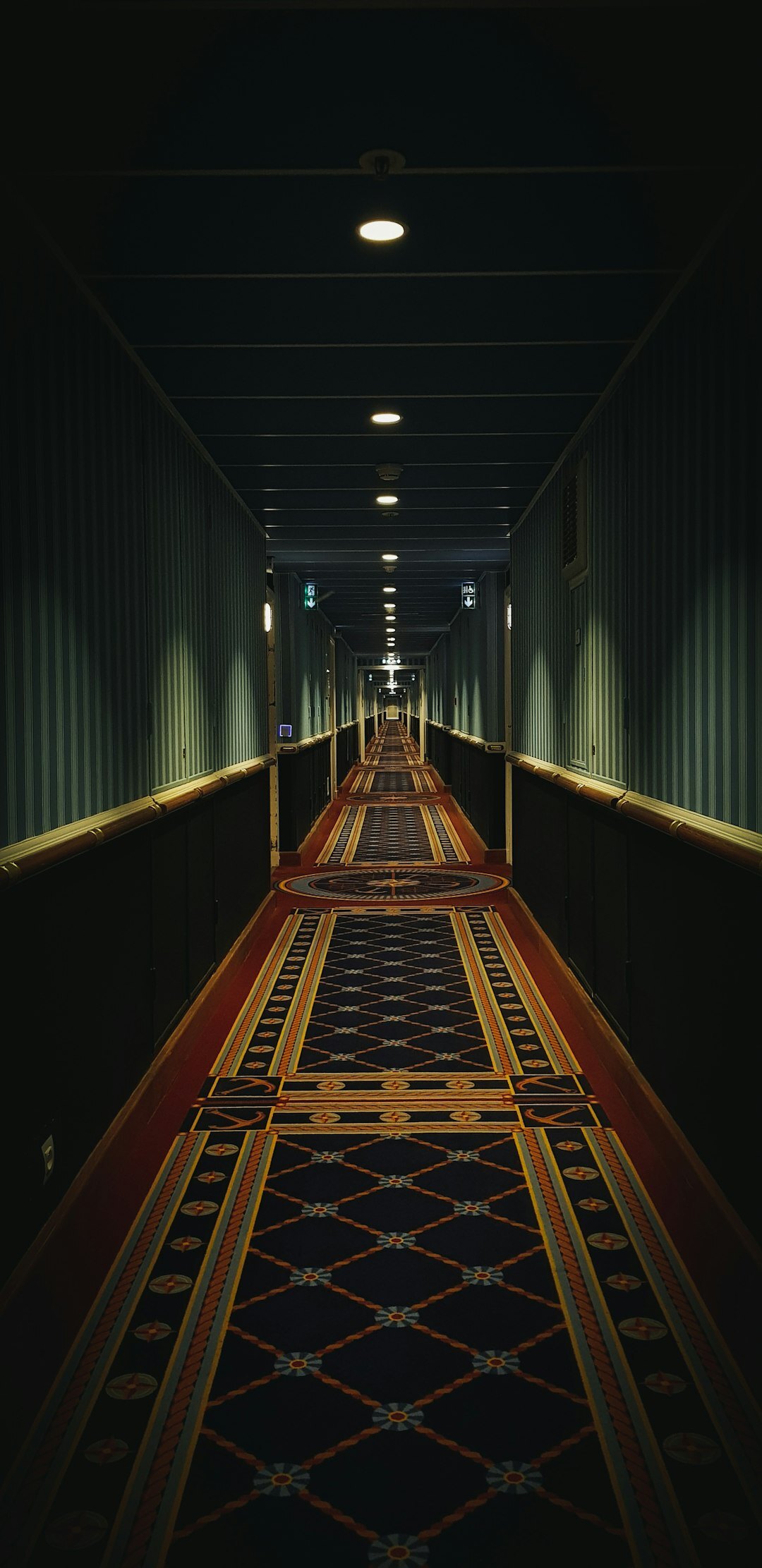 Dim hotel corridor with vintage lamps and patterned carpet