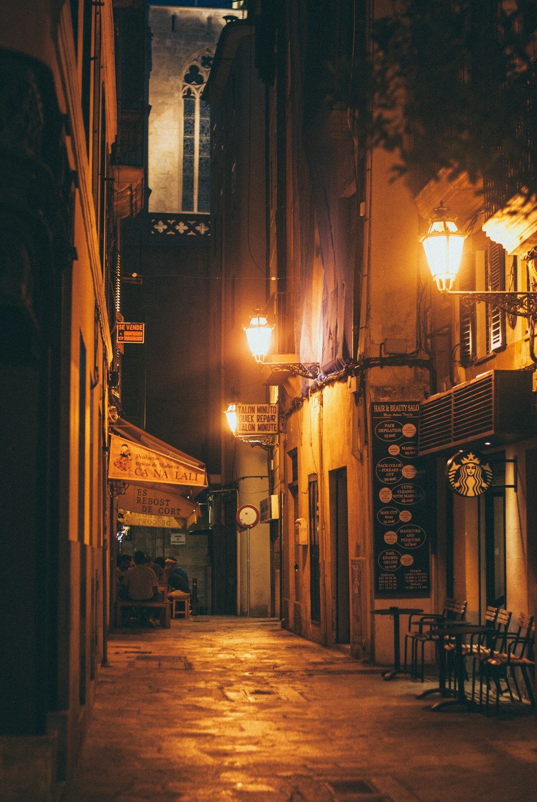 Old European coastal town street at dusk with warm lights